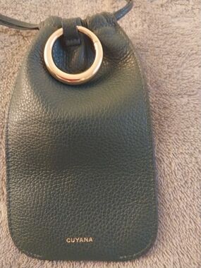Cuyana Dark Green Pebbled Leather Eyeglass holder with attached key holder.